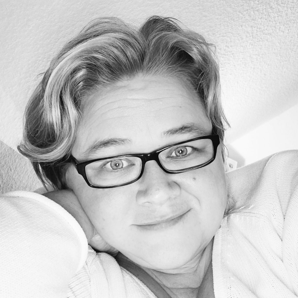 Ein Bild von Birgit Karstens. Blonde Frau mit schwarzer Brille.